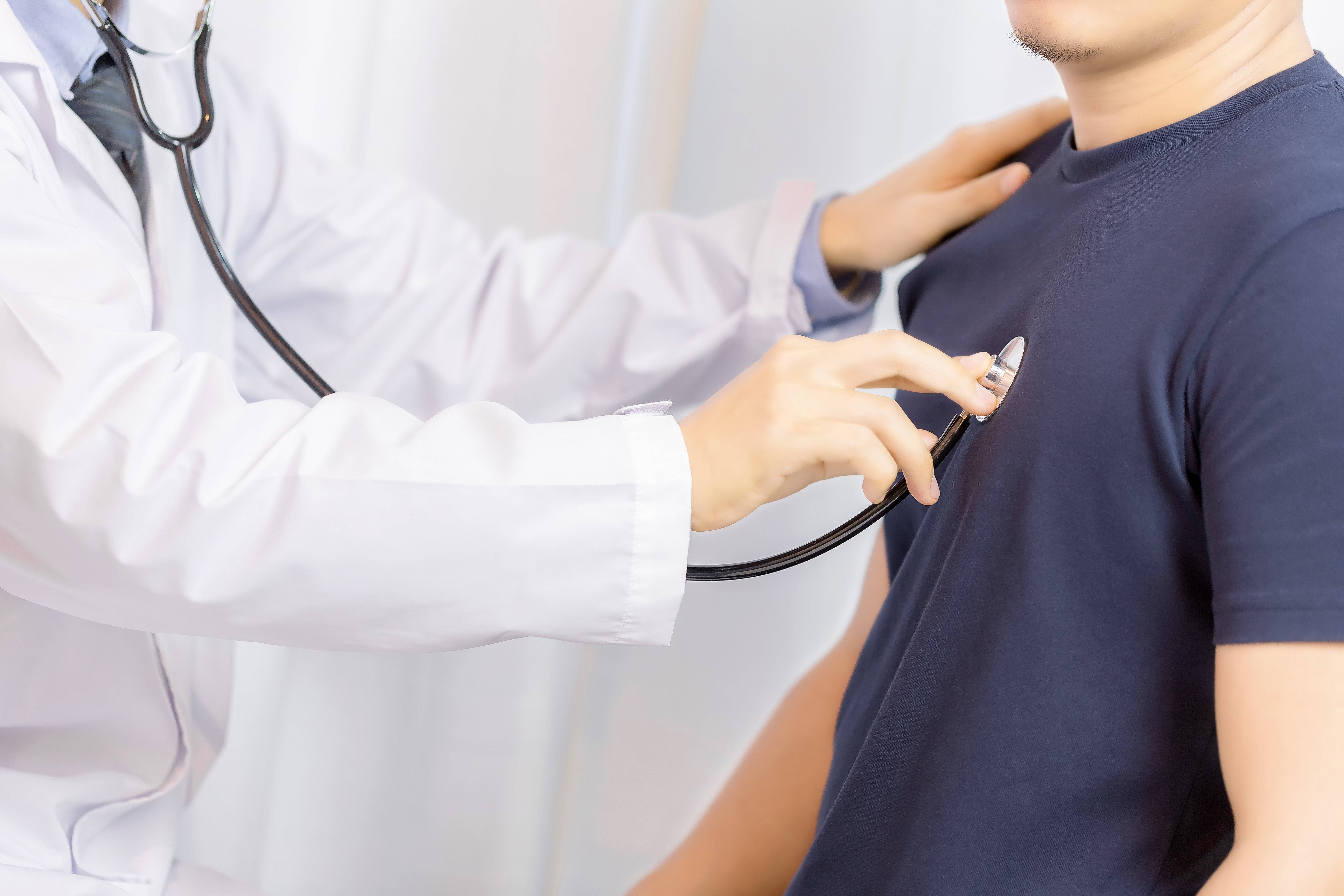 hombre-joven-del-examen-del-doctor-con-el-estetoscopio-en-hospital