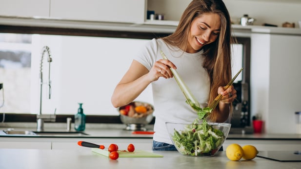young-woman-making-salad-kitchen